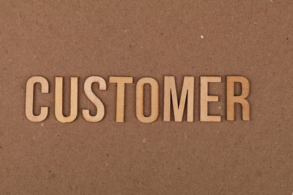 Wooden letters spelling Customer on craft paper